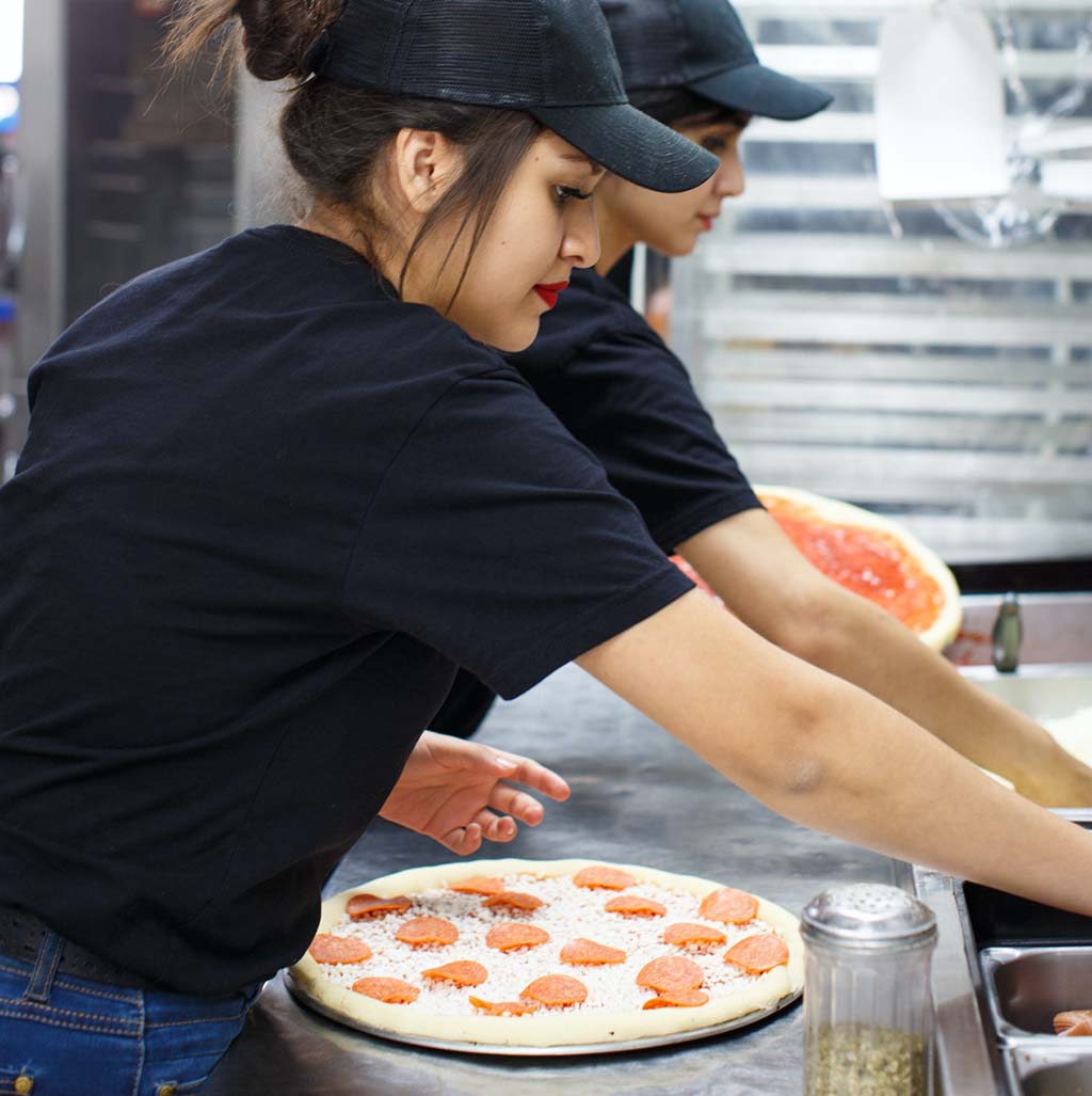 employees making pizza