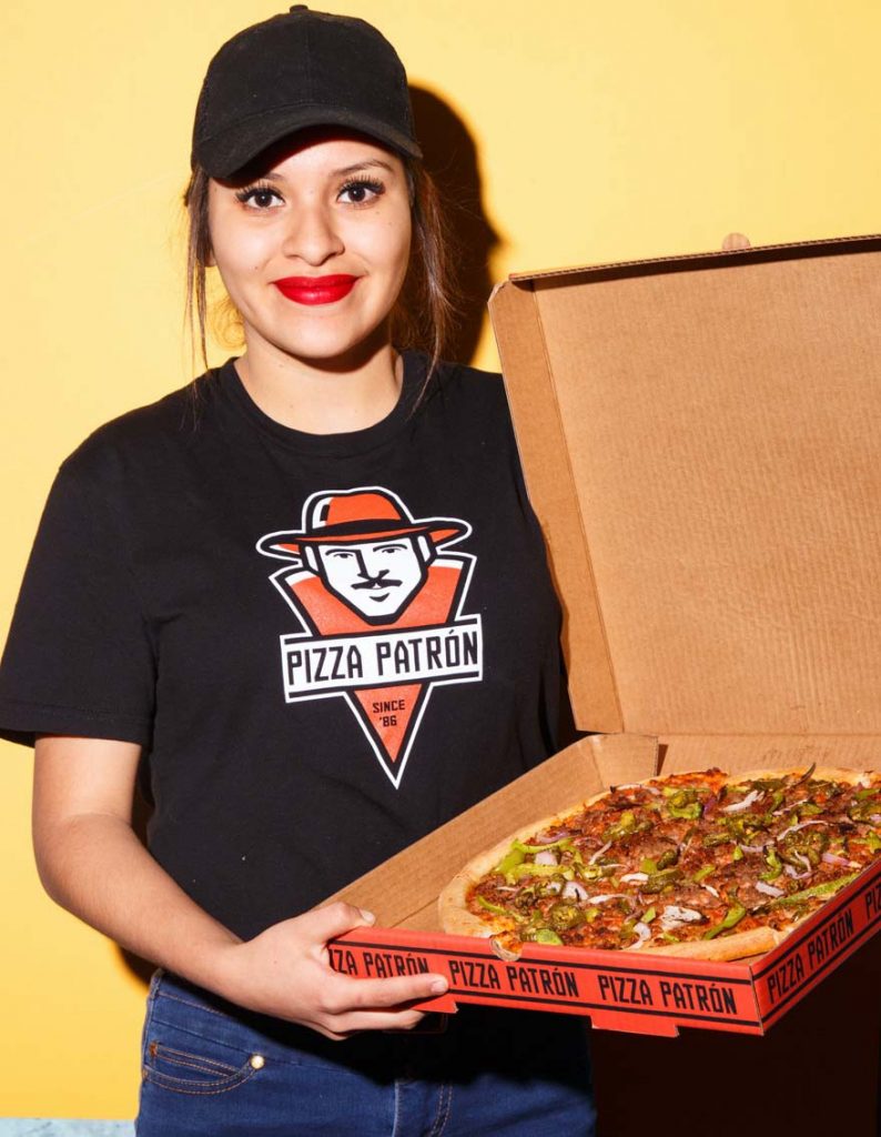 employee holding pizza